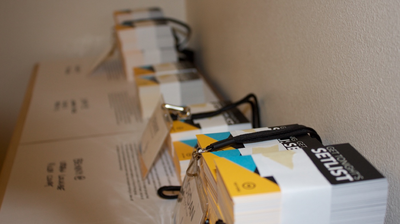 Printed setlist cards and field tester lanyards stacked and ready to hand out